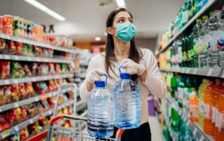 Frau beim Notvorrat anlegen im Supermarkt