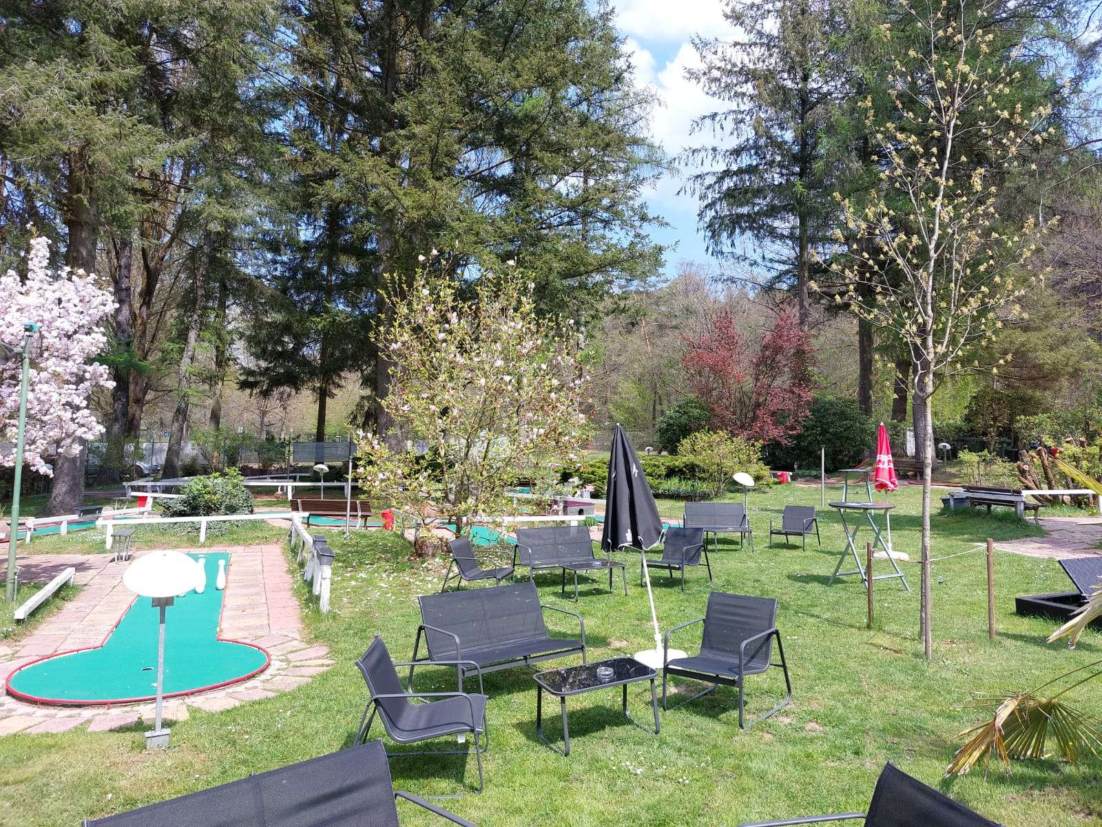 Teil der Minigolfanlage am Gelterswoog mit Stühlen und Tischen